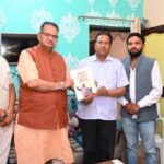थानीगांव निवासी राजपाल सिंह को डा0 अम्बेडकर की जीवनी भेंट करते मंत्री गणेश जोशी